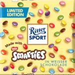 Ritter Sport Smarties al Cioccolato Bianco. Il successo al cioccolato degli anni '90 è tornato. Ricordate il delizioso cioccolato al latte Ritter Sport Smarties? Ora potete finalmente gustare di nuovo questa deliziosa tavoletta. Preparatevi a un sogno di finissimo cioccolato al latte, impreziosito da croccanti Smarties. Le gocce di cioccolato colorate trasformano questa delizia in una delizia colorata e croccante. Questa nuova edizione limitata tanto richiesta fa un grande ritorno SI, ma solamente per un tempo MOLTO LIMITATO.