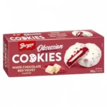 Bergen Obsession Cookies White Chocolate Red Velvet 128 gr. Cookies red velvet con ripieno e copertura al cioccolato bianco. Morbidi, golosi e super premium. Bergen Obsession Cookies White Chocolate Red Velvet è una variante premium dal look elegante e dal gusto intenso dessert-style.Questi cookies combinano un biscotto red velvet morbido e leggermente cacao con una cremosa farcitura al cioccolato bianco, il tutto ricoperto da una glassa bianca arricchita da crunchy bits al cacao. Il contrasto tra il sapore vellutato del red velvet e la dolcezza del white chocolate crea un profilo ricco, cremoso e super indulgent, perfetto per chi ama snack dolci in stile bakery americana. La confezione premium li rende ideali anche per regalo, candy box o assortimenti internazionali di fascia alta.