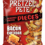 Pretezel Smoky Bacon Cheddar 110 gr. Pretzel Pete Pieces Smokey Bacon Cheddar è uno degli snack più apprezzati del marchio americano Pretzel Pete. A differenza dei classici mini pretzel, questa versione è composta da pezzi di pretzel spezzati, più spessi e croccanti, ricoperti da un ricco condimento al bacon affumicato e formaggio cheddar.