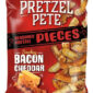 Pretezel Smoky Bacon Cheddar 110 gr. Pretzel Pete Pieces Smokey Bacon Cheddar è uno degli snack più apprezzati del marchio americano Pretzel Pete. A differenza dei classici mini pretzel, questa versione è composta da pezzi di pretzel spezzati, più spessi e croccanti, ricoperti da un ricco condimento al bacon affumicato e formaggio cheddar.